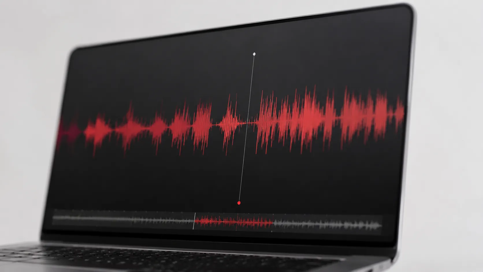 macOS Voice Memos waveform interface displayed on a MacBook screen for audio recording