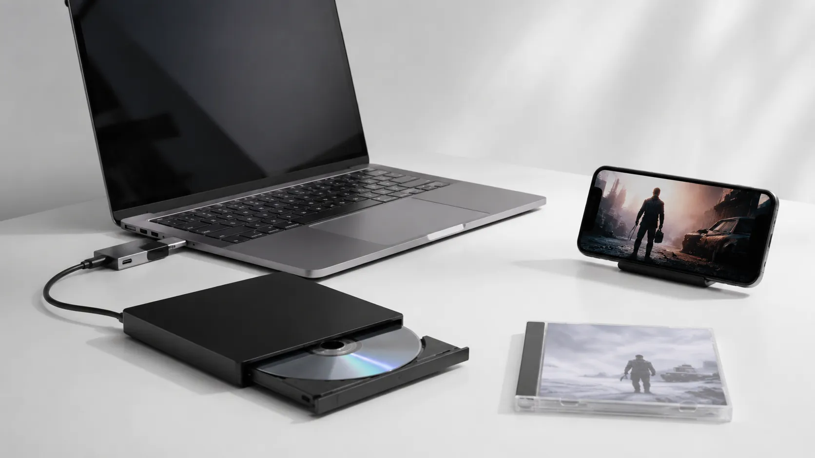 MacBook Pro connected to external DVD drive with iPhone showing converted movie file on white desk